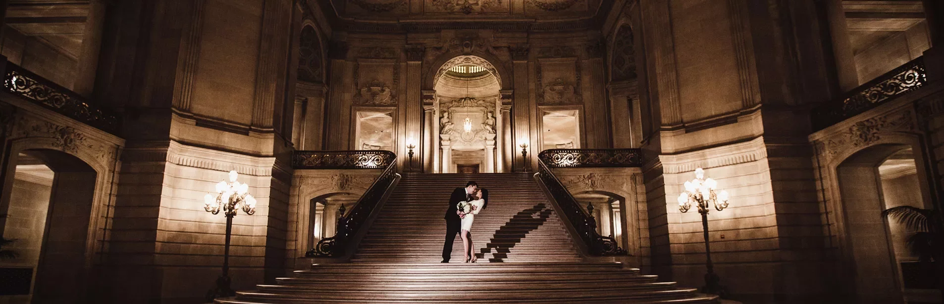 couple embracing on the grand staircase of San Francisco's City Hall